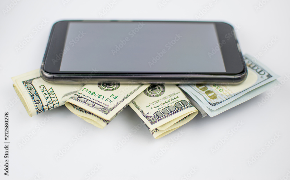 Dollars and mobile phone on a light background. The concept of expensive conversations, money spending on communication., Electronic payments. Dollars and mobile phone on a light background. The concept of expensive conversations, money spending on communication., Electronic payments.