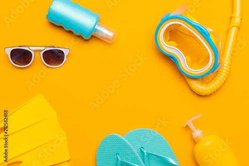 Composition of beachwear and accessories on a yellow background