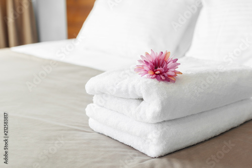 handdoeken en bloem op bed in hotelkamer