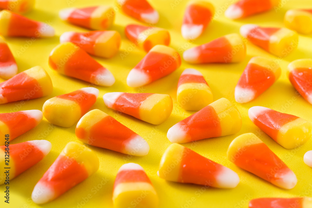 Typical halloween candy corn on yellow background. Typical halloween candy corn on yellow background.