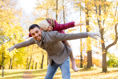 family, season and people concept - happy father and little daughter playing at autumn park © Syda Productions