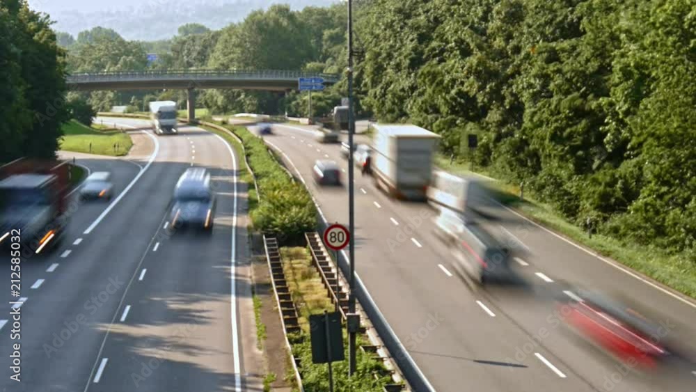A timelapse of fast moving traffic on a four-lane road short after rush hour. Vehicles have a good amount of motion blur.