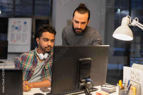 deadline, technology and people concept - creative team with computers working together late at night office