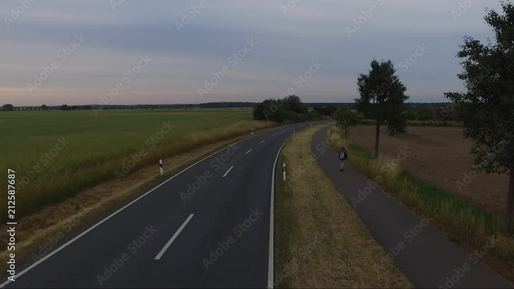 Drone Shot of an girl on the skateboard on a street. Drone Shot of an girl on the skateboard on a street.