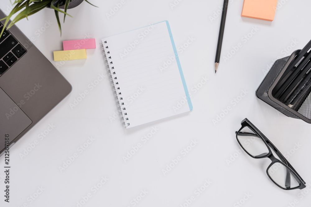 Top view of modern workspace office desk table with note page blank Top view of modern workspace office desk table with note page blank