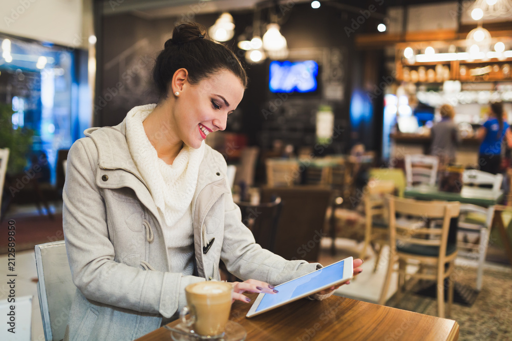 Attractive young woman using tablet in cafe Attractive young woman using tablet in cafe