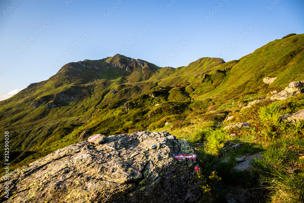 Wegmarkierung am Berg beim Wandern mit Gipfel im Hintergrund