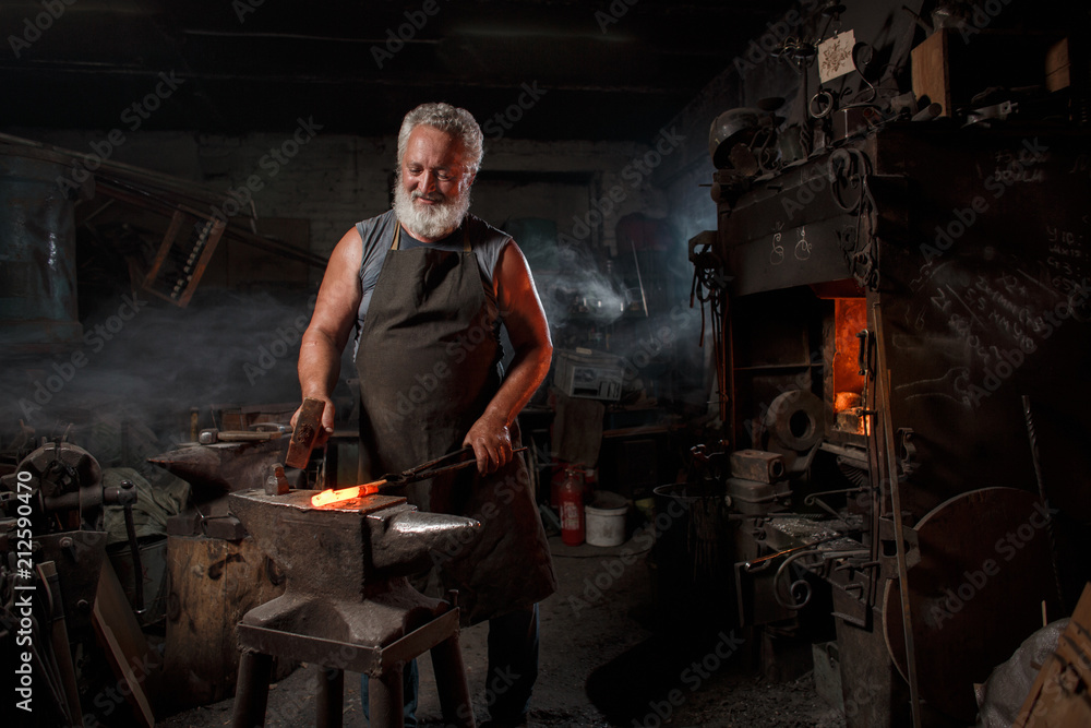 Blacksmith with brush handles the molten metal Blacksmith with brush handles the molten metal