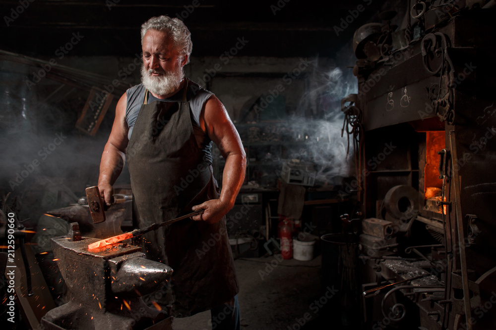 Blacksmith with brush handles the molten metal Blacksmith with brush handles the molten metal