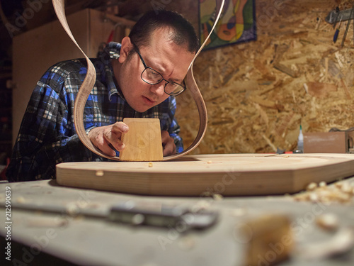 The process of making a classical guitar. Remove excess glue after gluing the tailblock. photo