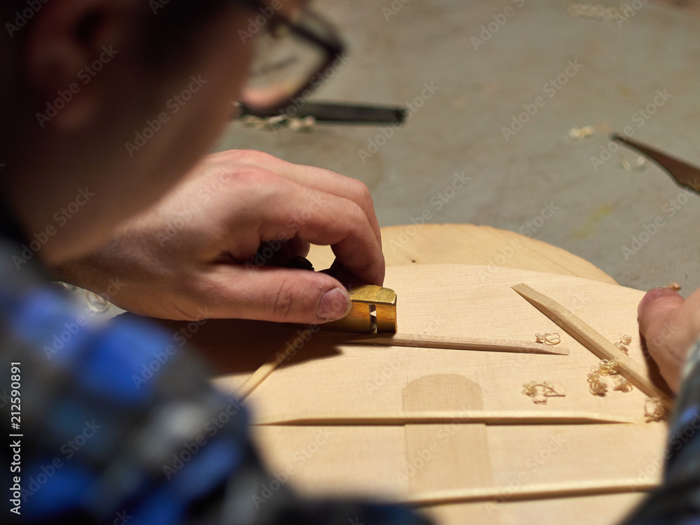 The process of making a classical guitar. Making the right shape of a brace guitar. The process of making a classical guitar. Making the right shape of a brace guitar.