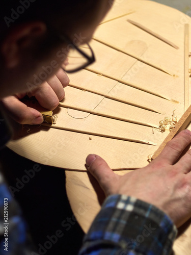 The process of making a classical guitar. Making the right shape of a brace guitar.