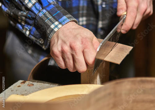 The process of making a classical guitar. Adjust the sides of the guitar to fit.