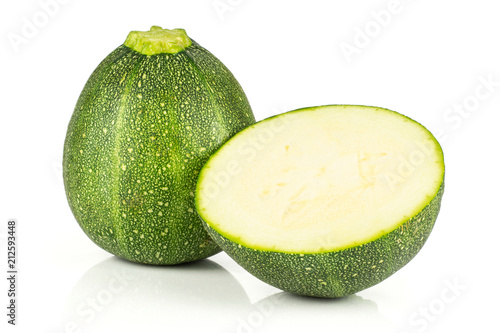 One round zucchini and one section half isolated on white background fresh summer squash.