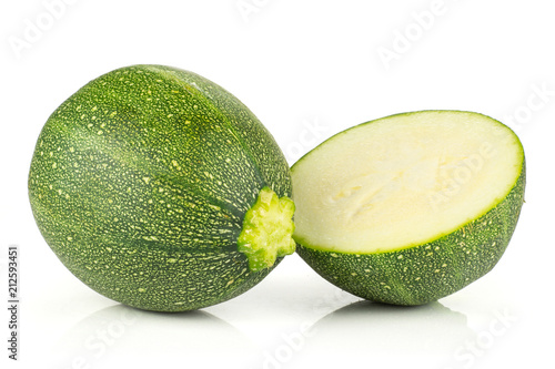 One round zucchini with one section half isolated on white background fresh summer squash.