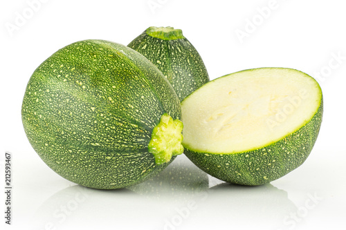Two round zucchini and one section half isolated on white background fresh summer squash.