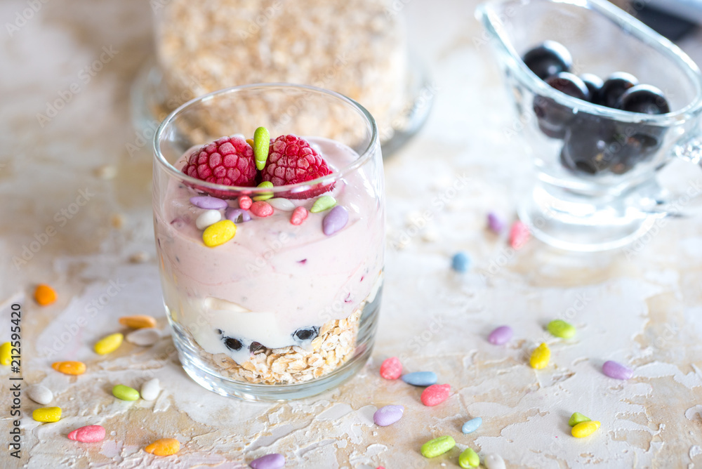 Yogurt, muesli and fresh fruit salad in a glass bowl on a wooden table, front view with details, space for text Yogurt, muesli and fresh fruit salad in a glass bowl on a wooden table, front view with details, space for text