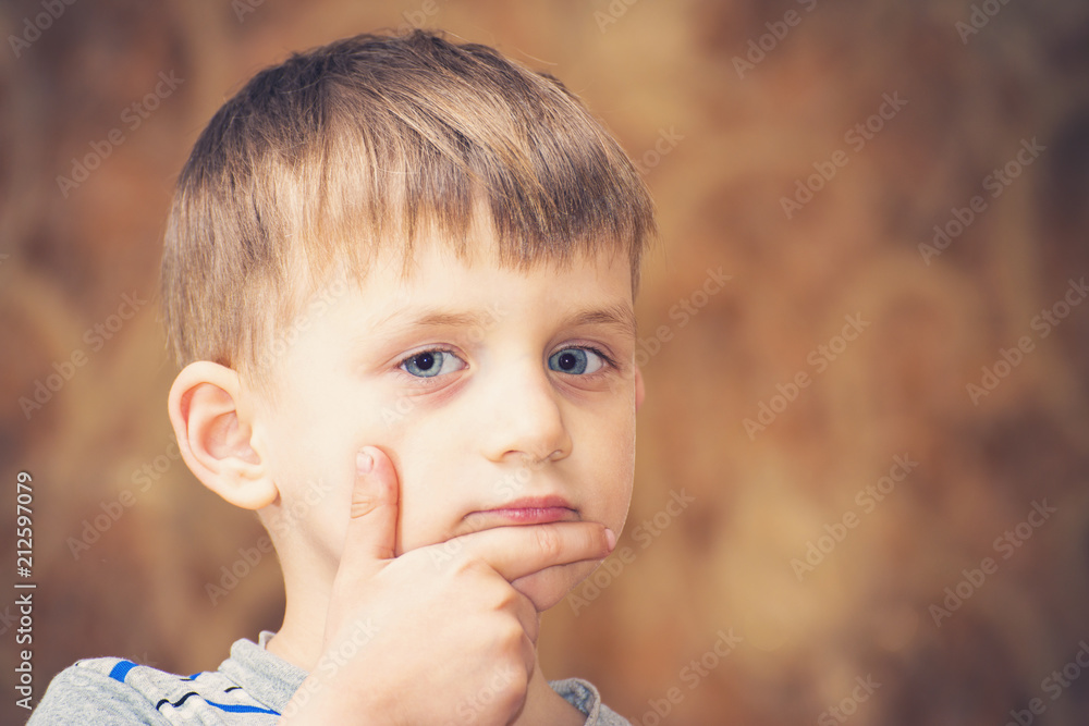 A boy strongly emotional shows a different face to the camera A boy strongly emotional shows a different face to the camera