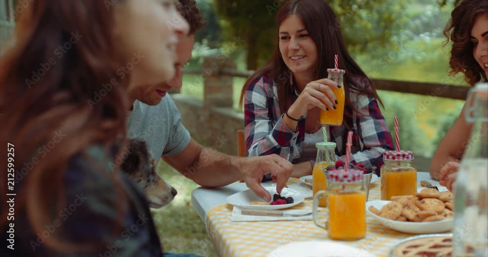 group of friends doing breakfast outdoors in a traditional countryside. shot in slow motion group of friends doing breakfast outdoors in a traditional countryside. shot in slow motion