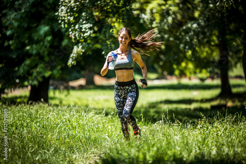 Young happy woman jogging outdoor at the park .Green environment and spring concept.