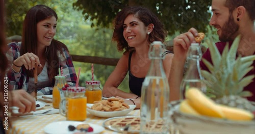 group of friends doing breakfast outdoors in a traditional countryside. shot in slow motion