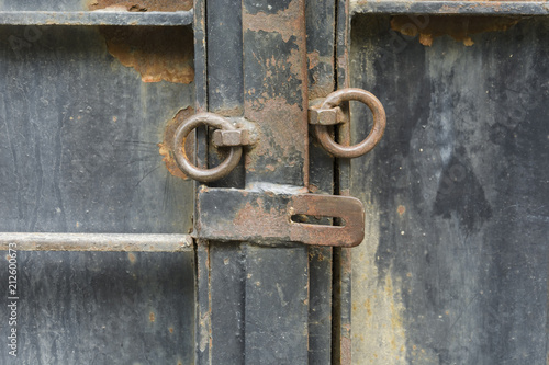 iron door with old opened lock with rusty rings.