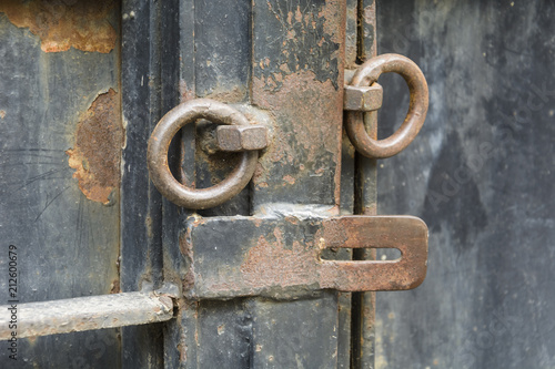 iron door with old opened lock with rusty rings.