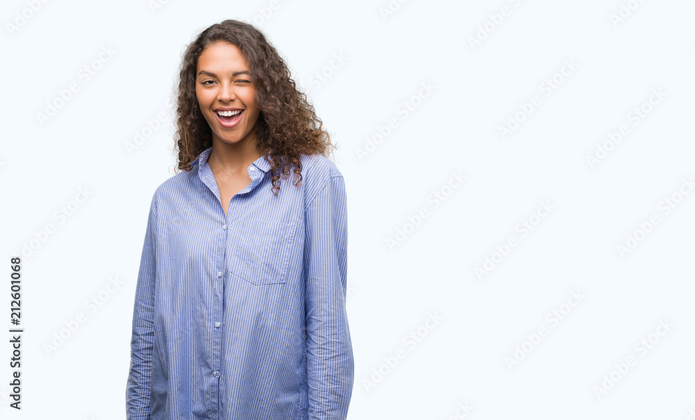 Young hispanic business woman winking looking at the camera with sexy expression, cheerful and happy face. Young hispanic business woman winking looking at the camera with sexy expression, cheerful and happy face.