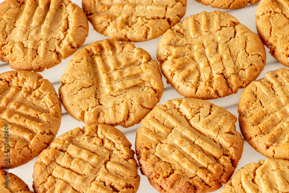 Delicious homemade peanut butter cookies on cooling rack. White wooden background. Healthy snack concept. Delicious homemade peanut butter cookies on cooling rack. White wooden background. Healthy snack concept.