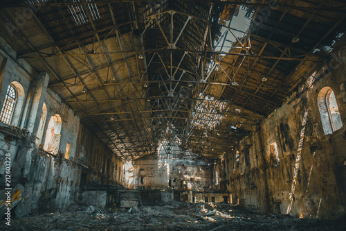 Abandoned ruins of industrial factory building inside, corridor view, perspective and sunlight, creepy ruins and demolition concept