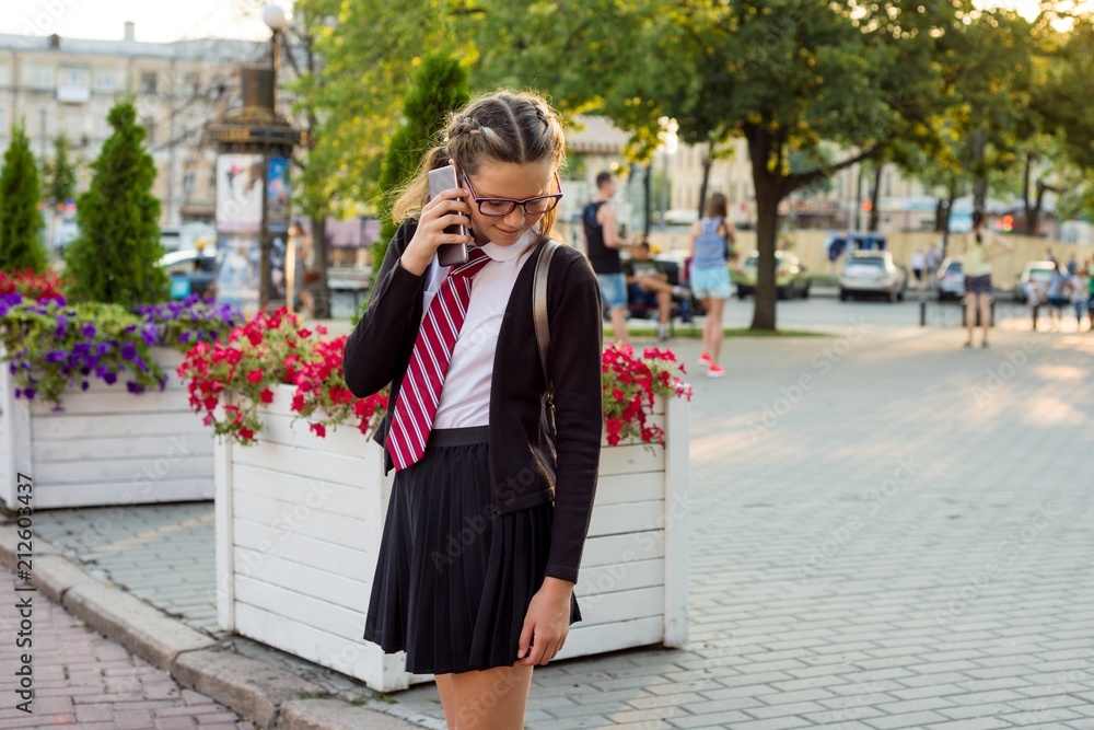Teenage girl high school student on city street talking on the phone Teenage girl high school student on city street talking on the phone