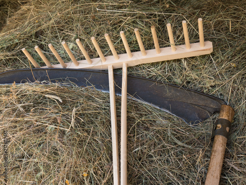 Foto A scythe and a rake with  hay