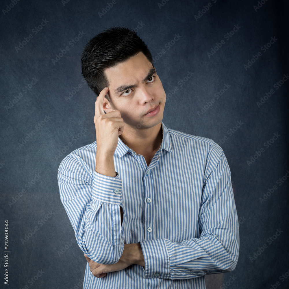 Portrait handsome young asian man wearing a white thinking and stress isolated on dark wall background.Asia man people. business concept. Portrait handsome young asian man wearing a white thinking and stress isolated on dark wall background.Asia man people. business concept.