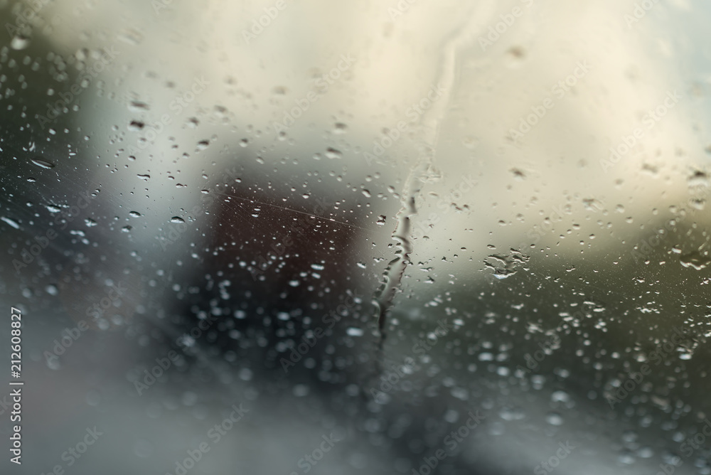Raindrops on glass car window with road light bokeh. water drop on the glass, evening storm. Raindrops on glass car window with road light bokeh. water drop on the glass, evening storm.