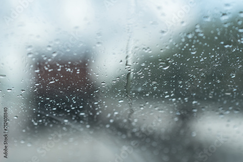 Raindrops on glass car window with road light bokeh. water drop on the glass, evening storm.