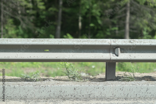 railing at road side on green forest background