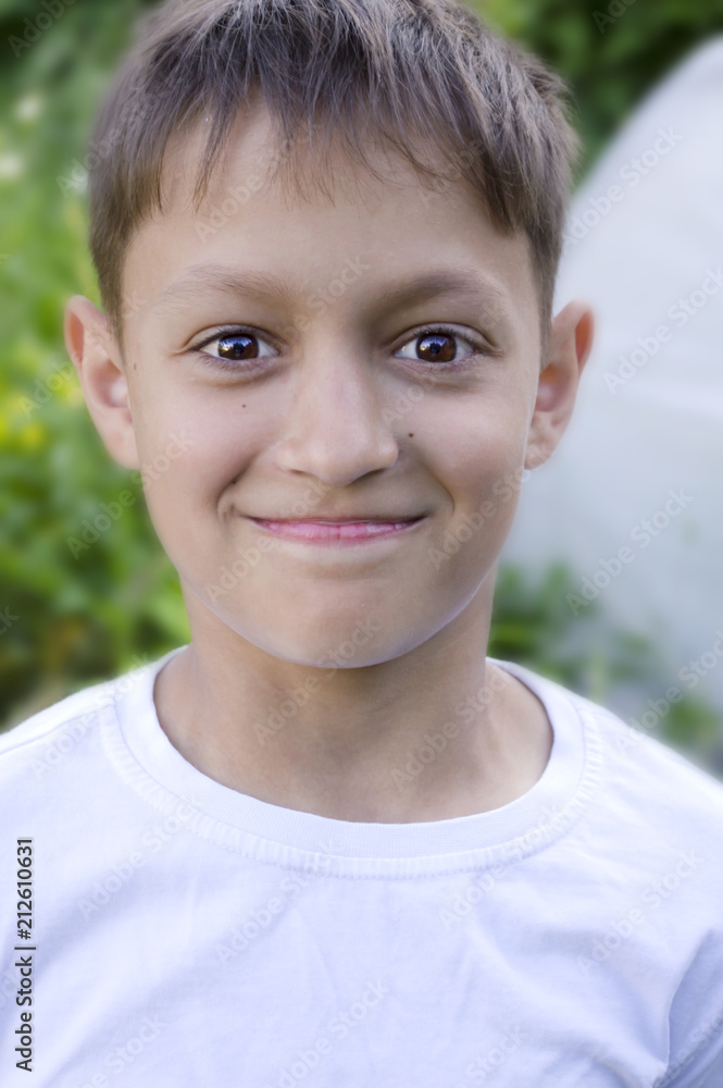 Portrait of a boy, dark hair with brown eyes in a white T-shirt, smiling  Stock Photo | Adobe Stock