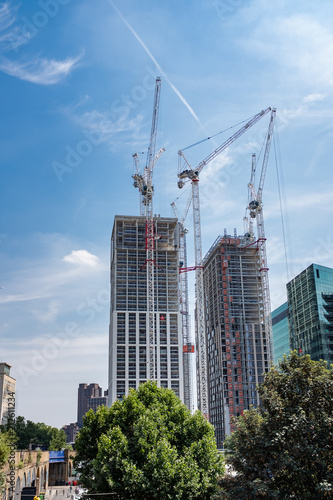Construction of two skyscrapers with large cranes in city centre