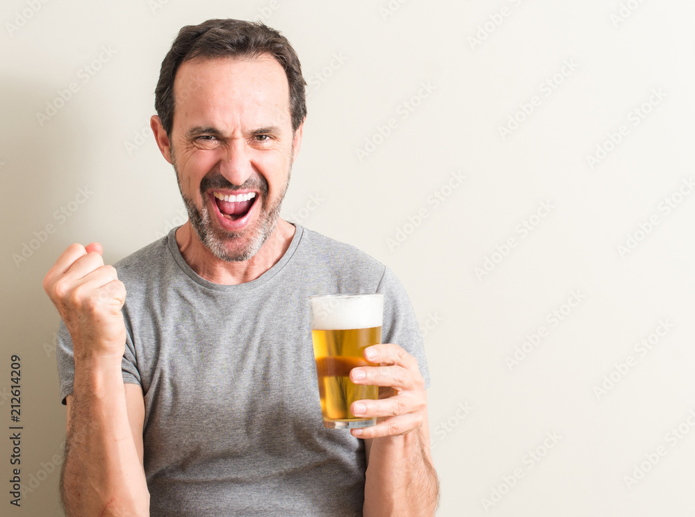 Senior man drinking beer screaming proud and celebrating victory and success very excited, cheering emotion Senior man drinking beer screaming proud and celebrating victory and success very excited, cheering emotion