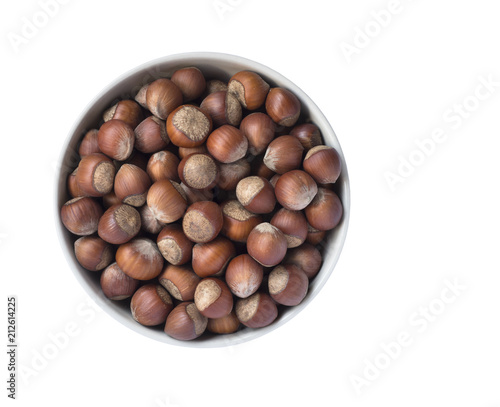 Hazelnuts in a bowl isolated on white background, top view.