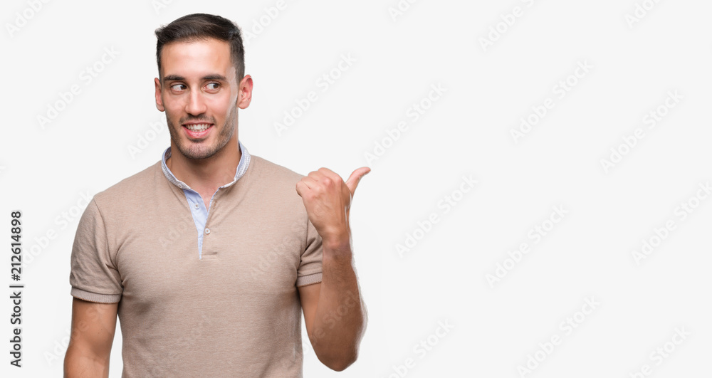 Handsome young man pointing with hand and finger up with happy face smiling Handsome young man pointing with hand and finger up with happy face smiling