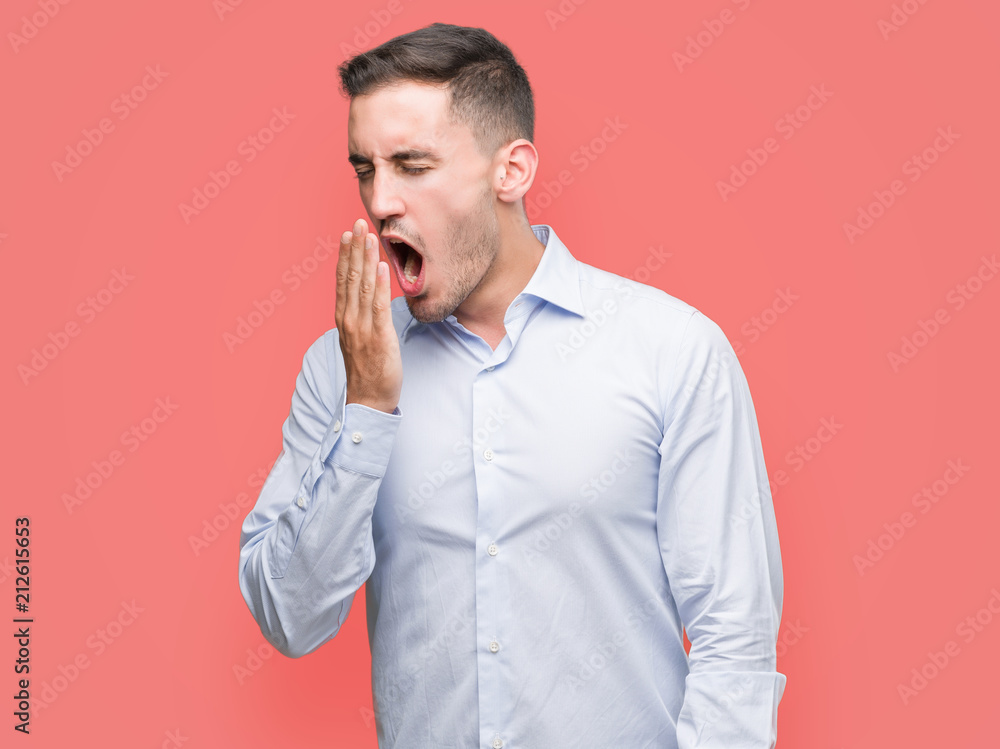 Handsome young businessman bored yawning tired covering mouth with hand. Restless and sleepiness. Handsome young businessman bored yawning tired covering mouth with hand. Restless and sleepiness.