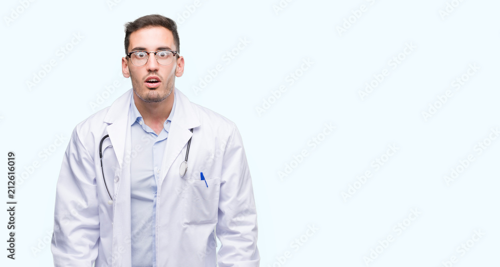 Handsome young doctor man afraid and shocked with surprise expression, fear and excited face. Handsome young doctor man afraid and shocked with surprise expression, fear and excited face.