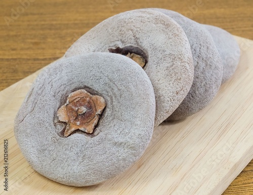 Dried Kaki or Persimmon Fruits on Wooden Tray photo