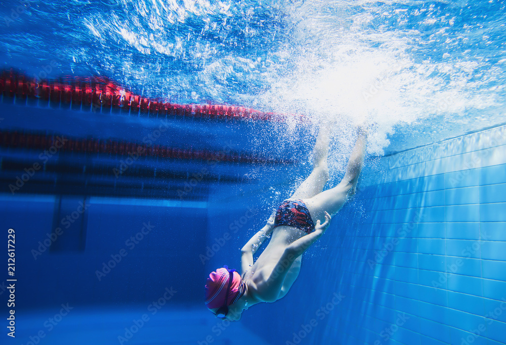 a little boy is having fun under water, tumbling and grimacing, making faces