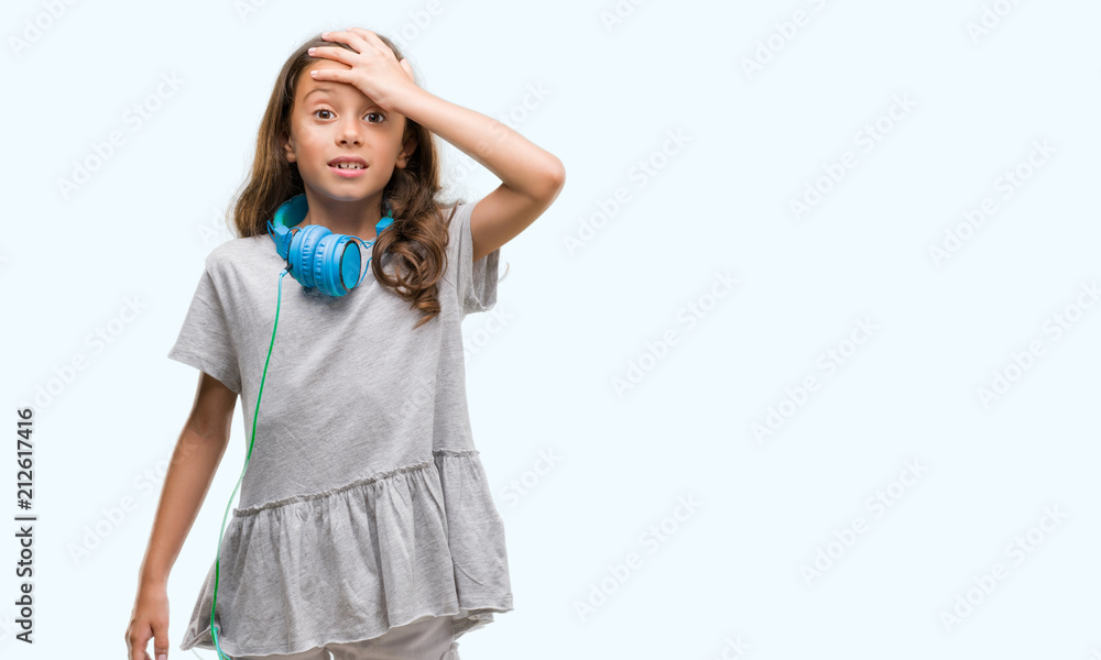 Brunette hispanic girl wearing headphones stressed with hand on head, shocked with shame and surprise face, angry and frustrated. Fear and upset for mistake. Brunette hispanic girl wearing headphones stressed with hand on head, shocked with shame and surprise face, angry and frustrated. Fear and upset for mistake.