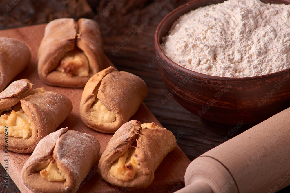 flour in clay bowl products for making cheesecakes on a wooden chopping board. Homemade Cottage cheese cookies on black background. still life composition flour in clay bowl products for making cheesecakes on a wooden chopping board. Homemade Cottage cheese cookies on black background. still life composition