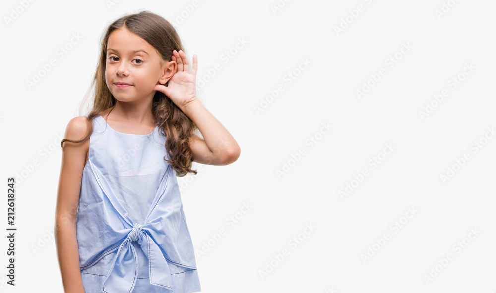 Brunette hispanic girl smiling with hand over ear listening an hearing to rumor or gossip. Deafness concept. Brunette hispanic girl smiling with hand over ear listening an hearing to rumor or gossip. Deafness concept.