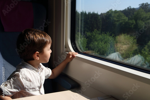 niño mirando por la ventanilla de un tren photo