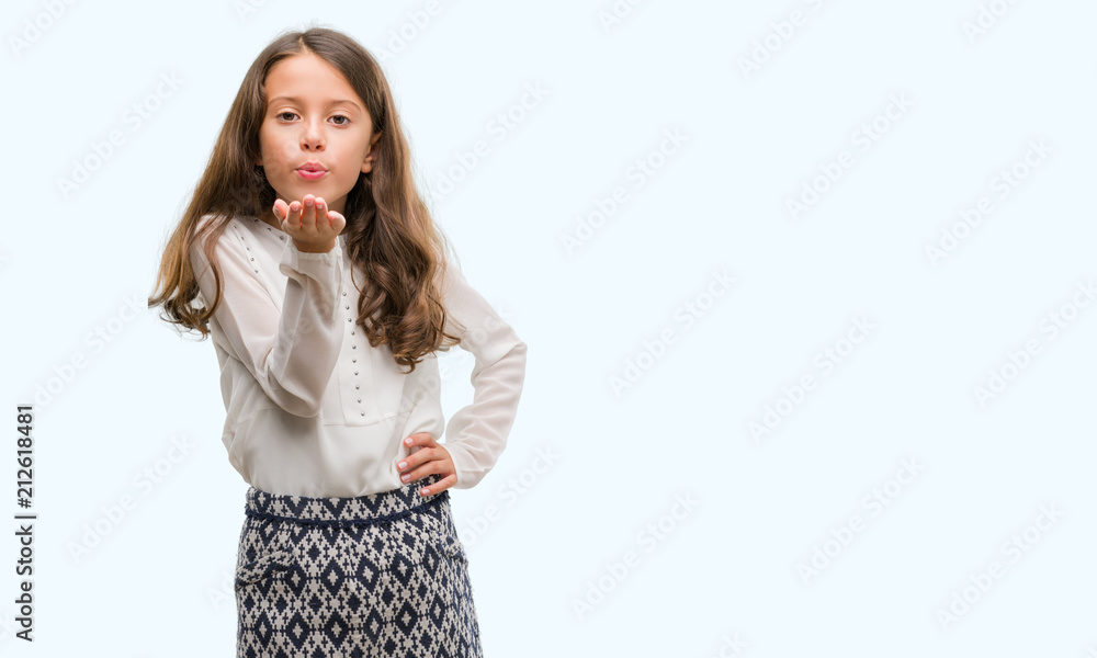 Brunette hispanic girl looking at the camera blowing a kiss with hand on air being lovely and sexy. Love expression. Brunette hispanic girl looking at the camera blowing a kiss with hand on air being lovely and sexy. Love expression.